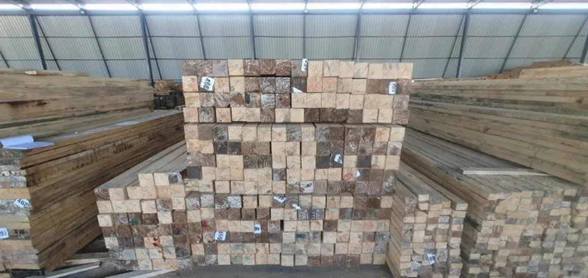 Square section sawn timber neatly stacked in warehouse